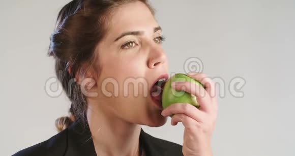 女人在白色的工作室里吃苹果视频的预览图