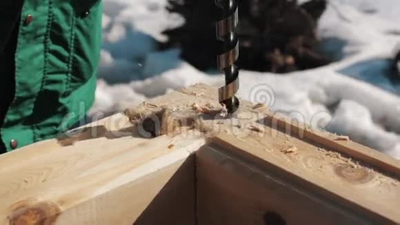 在两个木块角连接上的钻孔在外面制造锯末视频的预览图