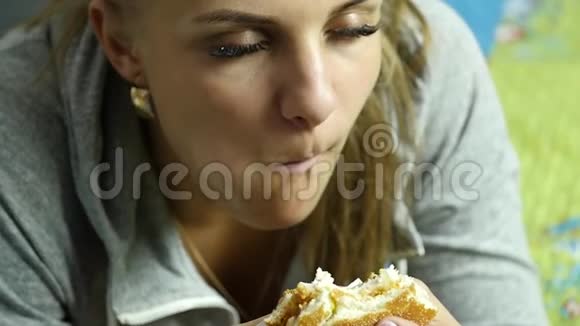 胖女人拿着快餐汉堡咀嚼它吃垃圾食品慢动作视频的预览图