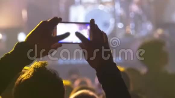 音乐摇滚音乐会上的人用智能手机拍照或录制视频视频的预览图