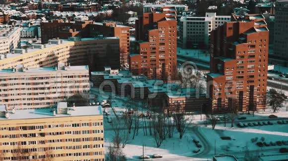 现代城市宿舍区阳光明媚的冬日里被雪覆盖的住宅视频的预览图