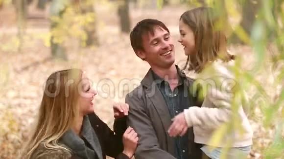一家人站在公园里聊天父亲把女儿抱在怀里视频的预览图