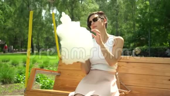 一个微笑兴奋的女孩在游乐园拿棉花糖的肖像视频的预览图