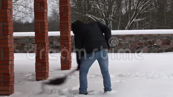 年轻人在冬天用雪铲视频的预览图