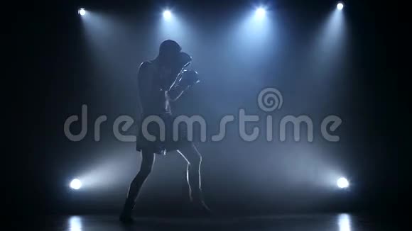 聚光灯下的拳击手是在演播室训练的慢动作视频的预览图