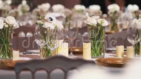 餐桌上摆着一排排酒杯和一朵朵白花视频的预览图