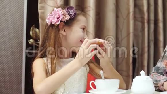 快乐的母亲和女儿正在厨房里喝带饼干的茶视频的预览图