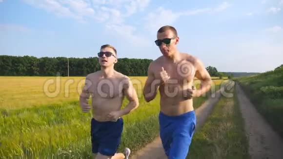 两个肌肉发达的男人在户外跑步和交谈年轻的运动员在球场上慢跑男运动员训练视频的预览图