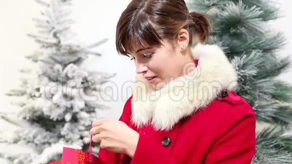 圣诞妇女打开袋子礼物和惊喜的微笑背景树视频的预览图