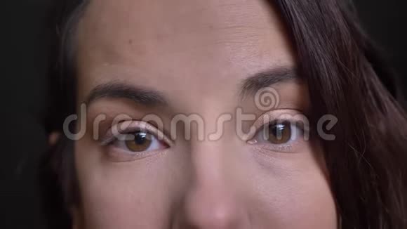 年轻美丽的白种人女性脸上的特写镜头棕色的眼睛直视着镜头带着微笑的表情视频的预览图