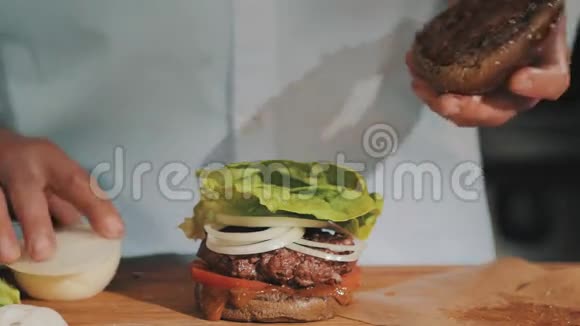 男厨师长穿着白色长袍完成了汉堡的制作视频的预览图