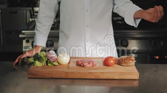 穿白色长袍的男厨师把粗盐滴在生肉上视频的预览图