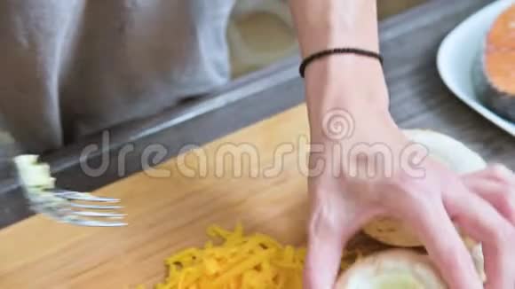 女性手的特写用酱油和磨碎的奶酪填充新鲜的豪奇尼蘑菇筹备工作视频的预览图