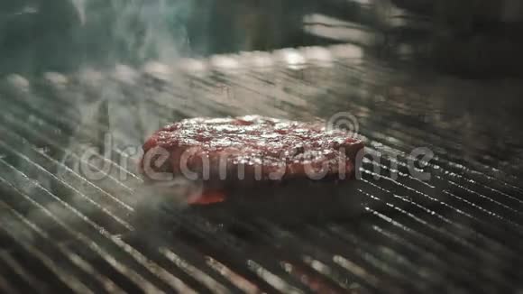 男人的手把粗盐滴在烧烤架上煮肉视频的预览图