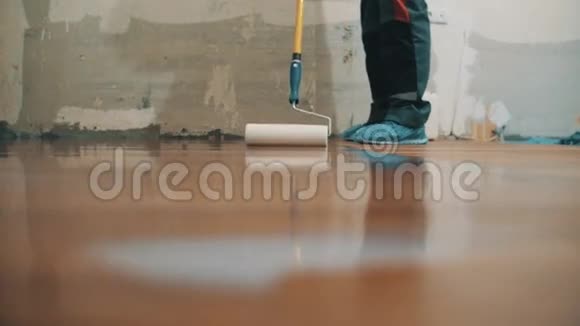 在新地板上涂上抛光剂的工作裤视频的预览图