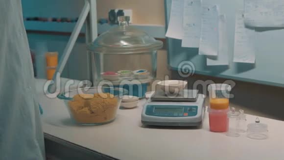 橡胶手套的科学家拿动态沙把它放在电子重物上视频的预览图