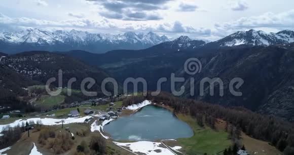 秋天在村庄和蓝湖之上向松松落叶林和雪山前进秋季阿尔卑斯山户外视频的预览图