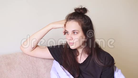 生病的年轻女子坐在家里头痛得厉害视频的预览图