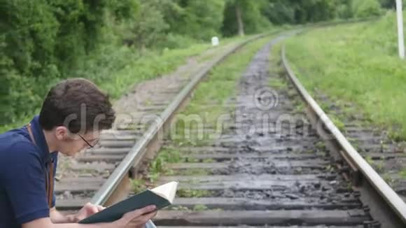 年轻人在铁路上看书视频的预览图