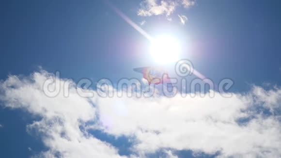 风筝对着太阳在蓝天上飞翔风筝在美丽的天空中飞翔有太阳和云彩视频的预览图
