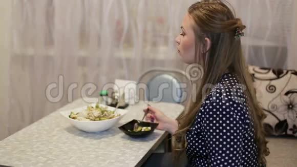 年轻漂亮的女孩在房子的客厅吃晚饭视频的预览图