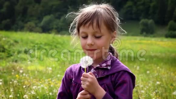 小女孩吹蒲公英的花朵视频的预览图