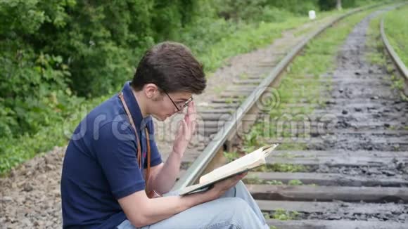 年轻人在铁路上看书视频的预览图