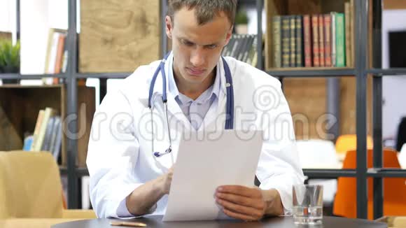 医务处男医生往下看文件思考视频的预览图