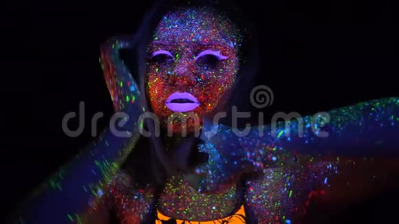 紫色头发在霓虹灯中跳舞的美丽女人的肖像有荧光创意的迷幻少女视频的预览图