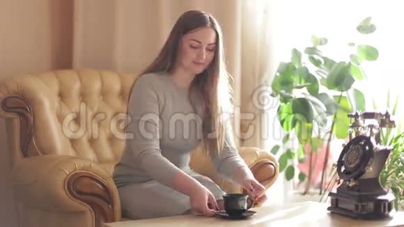 美丽的年轻女子享受清晨的新鲜咖啡和日出在家的生活方式视频的预览图