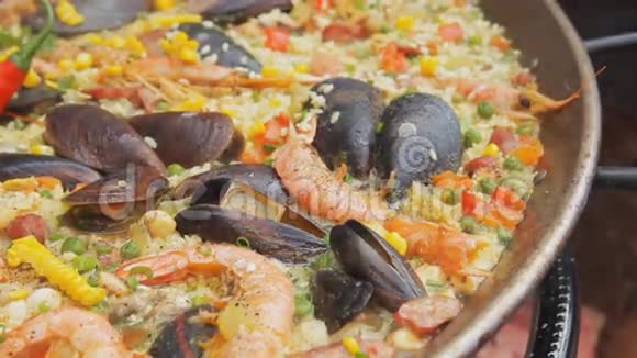 西班牙海鲜饭和黄米饭虾和贻贝在食品市场上烹饪街头美食节传统视频的预览图