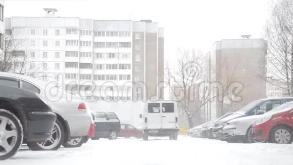 冬天城市里一条被雪覆盖的街道上下着大雪视频的预览图