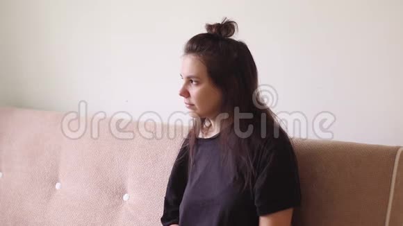 生病的年轻女子坐在家里流鼻涕视频的预览图