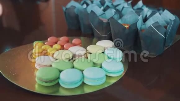 厨房桌上有五颜六色的马卡龙和迷你蛋糕视频的预览图