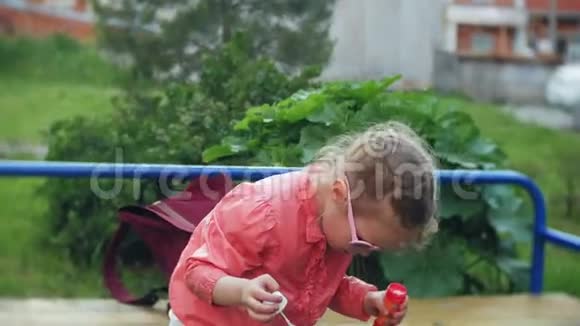 快乐的孩子在春天公园吹肥皂泡视频的预览图