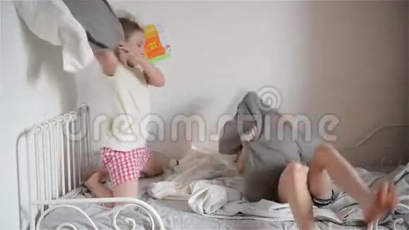 哥哥和姐姐在卧室的床上用枕头安排打架视频的预览图