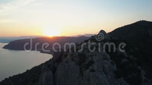 在美丽的黑海和日落天空背景下的群山上俯瞰日落视频的预览图