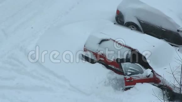男司机试图把他的汽车从雪堆里解救出来被雪覆盖的停车车厢视频的预览图