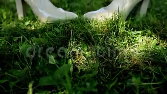 新娘的白色结婚鞋在草地上视频的预览图