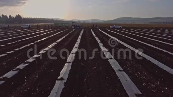 农场工人用拖拉机在田里工作的空中镜头视频的预览图