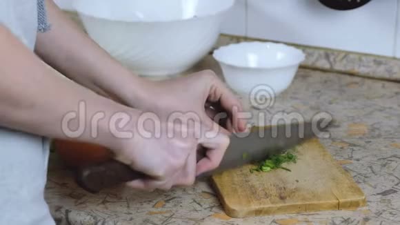 不可辨认的女人在厨房桌子上的切割板上切割迪尔把手举起来视频的预览图