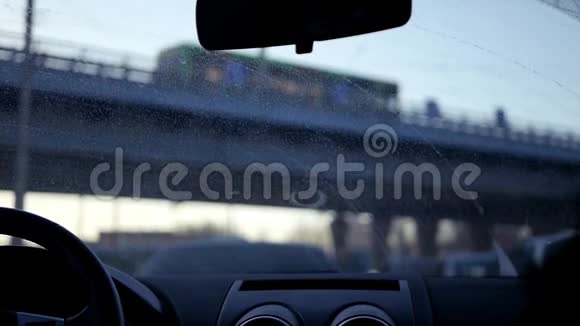 一辆汽车在一条挤满了汽车的道路上行驶它在桥下行驶太阳遮住了眼睛慢动作1920x1080视频的预览图