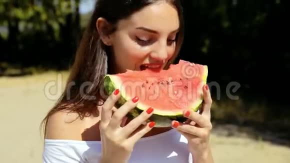 美丽性感的女人女孩在海滩上吃西瓜视频的预览图