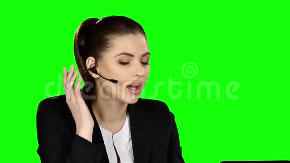 女接待员在电脑上工作在呼叫中心打电话绿色屏幕视频的预览图