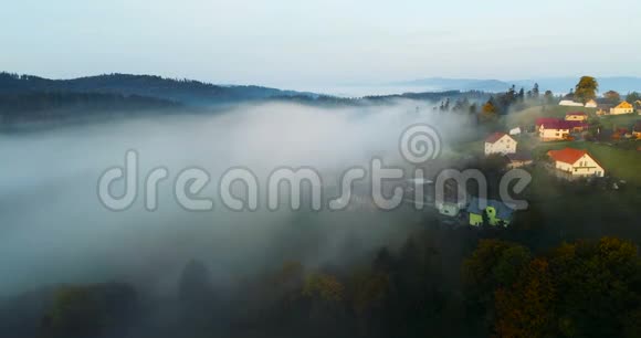 日出时无人机飞越梦幻般的雾山村视频的预览图