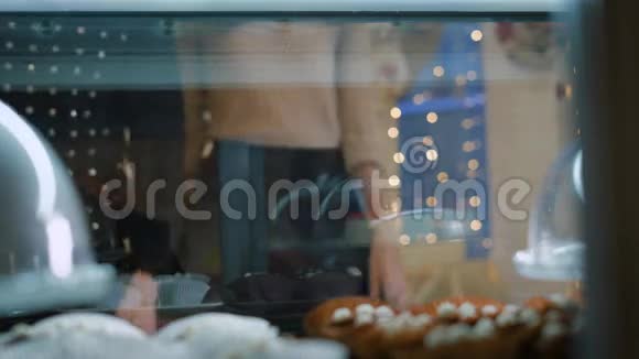 糖果店里漂亮的一对年轻人女孩和男孩自己选择蛋糕和甜点视频的预览图