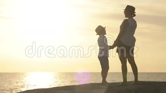 母亲和儿子带着夕阳在海滨大笑视频的预览图