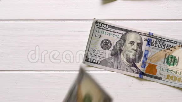 白色木桌上100美元的钞票视频的预览图