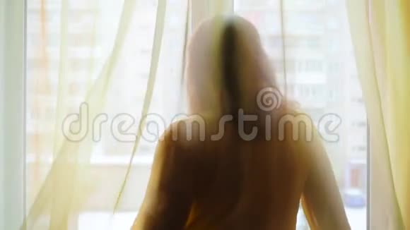 在阳光下在窗前跳舞的女孩视频的预览图