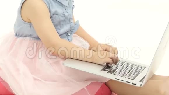 一个小女孩的手在笔记本电脑的钥匙上拍手白色背景视频的预览图